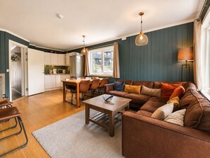 A modern living room with a sofa, coffee table, and dining area.