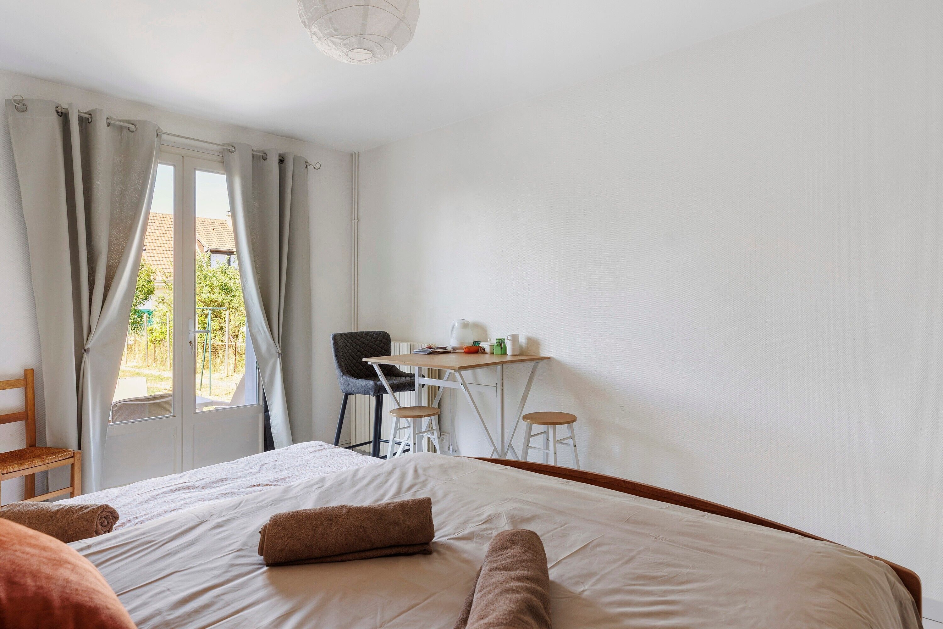Una camera da letto con un letto, una scrivania, una sedia e vista dalla finestra.