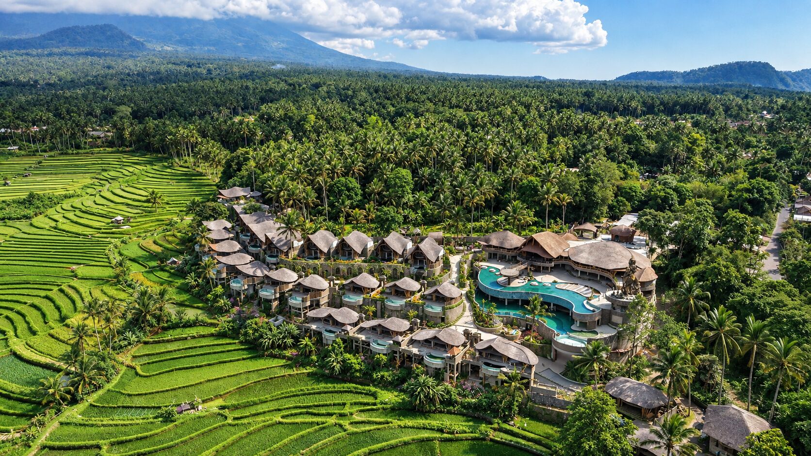 A resort with multiple bungalow-style buildings, a central pool, and terraced rice fields in the background.