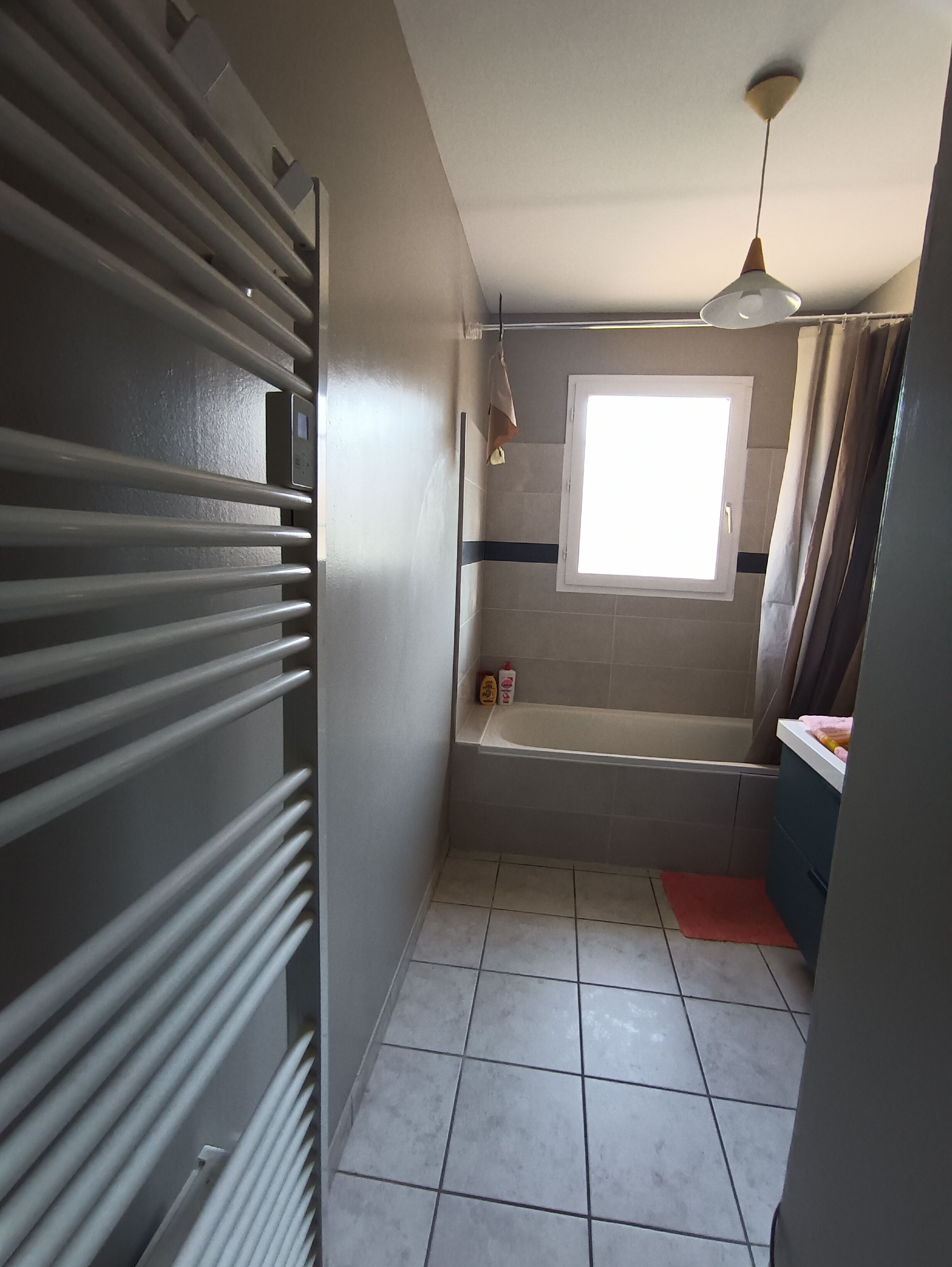 A bathroom with a bathtub, a window, and a ceiling fan.