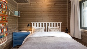 A wooden-paneled bedroom with a bed, dresser, and a shelf with books. - Modern apartment in Glomsrud Golsfjellet west (Gol)