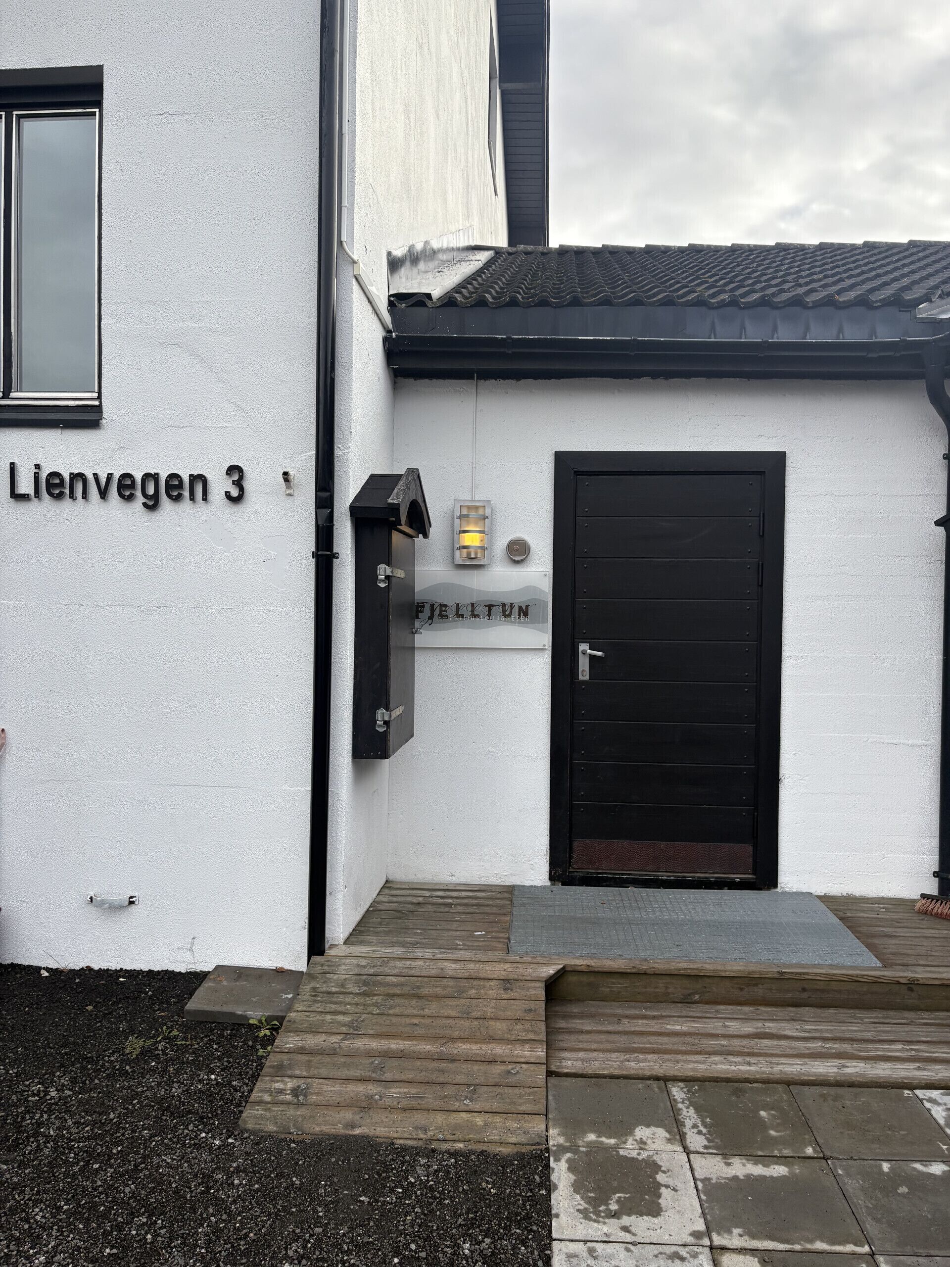 Rakennuksessa on valkoinen julkisivu, musta ovi ja pieni ikkuna.