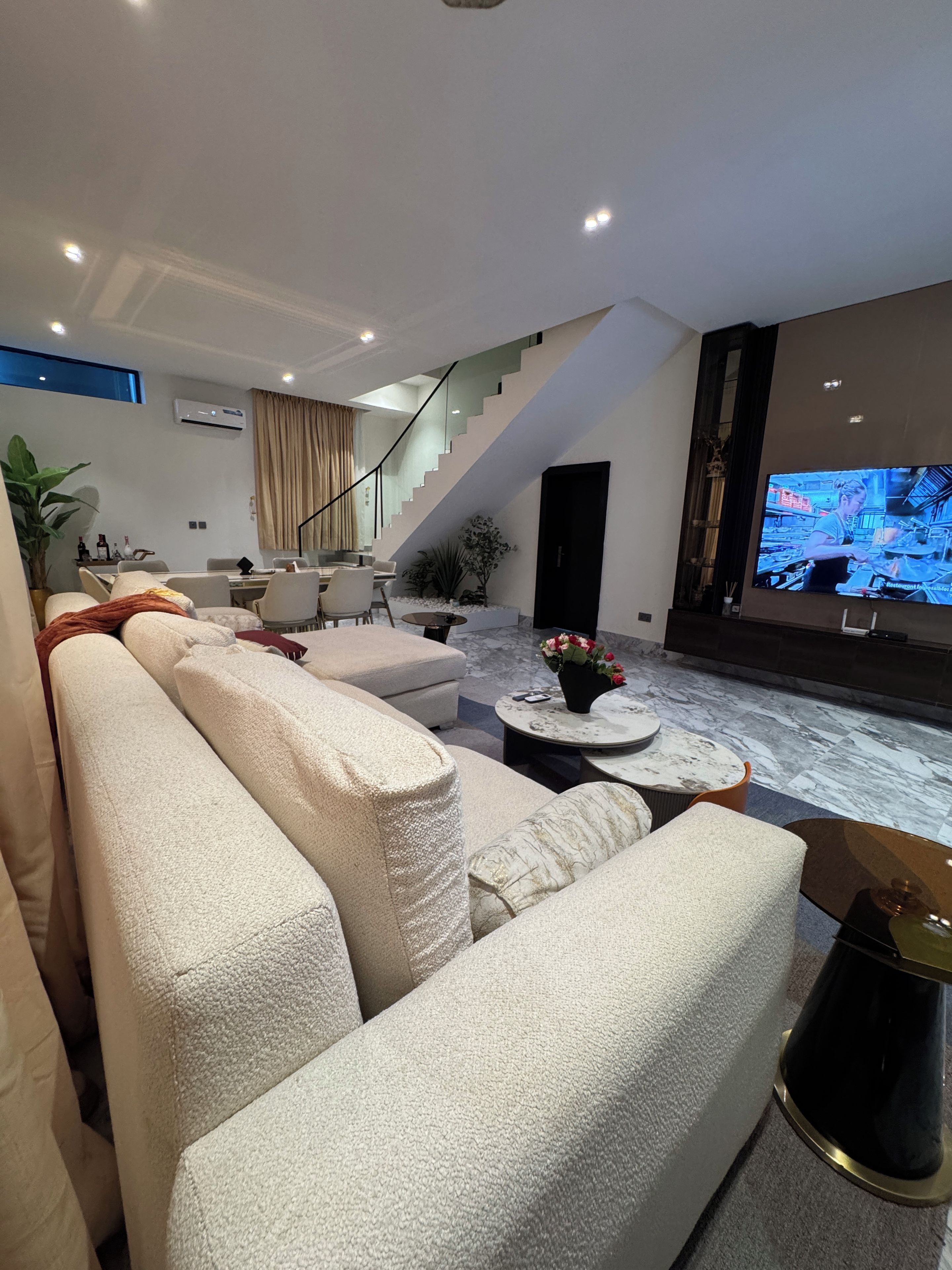 A modern living room with a sofa set, a coffee table, and a television.