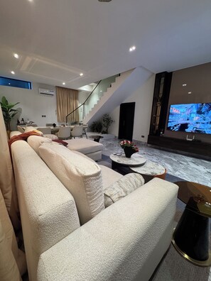 Un salon moderne comprenant un canapé, une table basse et un téléviseur.