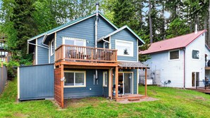 Une maison à deux étages avec un balcon, une véranda et un garage.