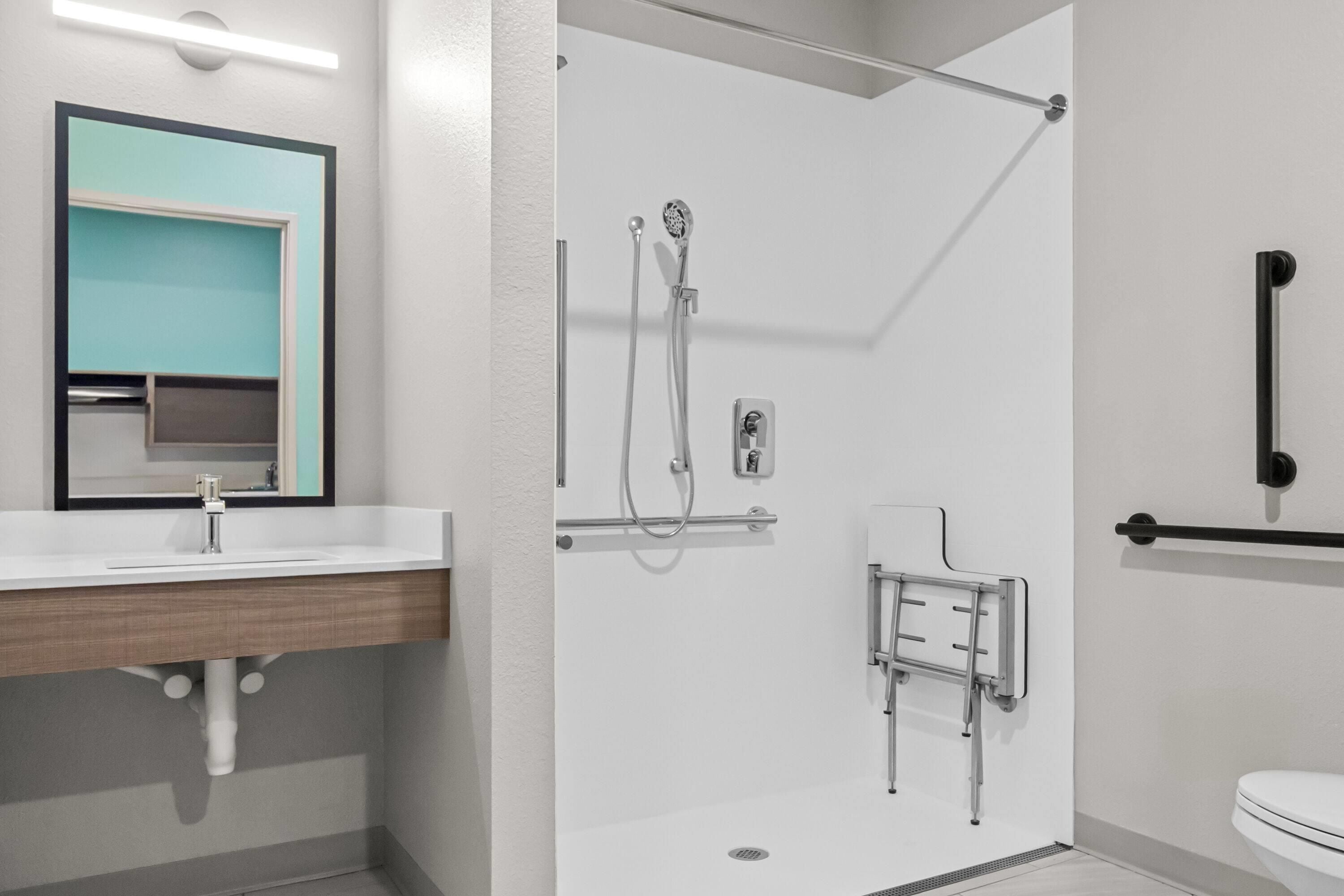 A modern bathroom with a shower, toilet, and sink.