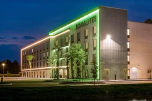 Un hotel con fachada moderna, varios ventanales y un letrero que dice 'ECHOSUITES'.