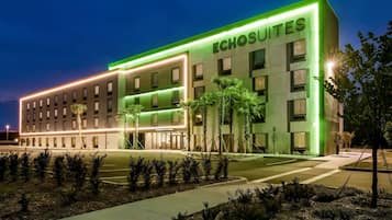 A hotel with a modern facade, multiple windows, and a sign reading 'ECHOSUITES'.