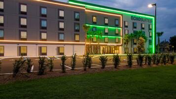 Un hotel con fachada moderna, varios pisos y una entrada bien iluminada.