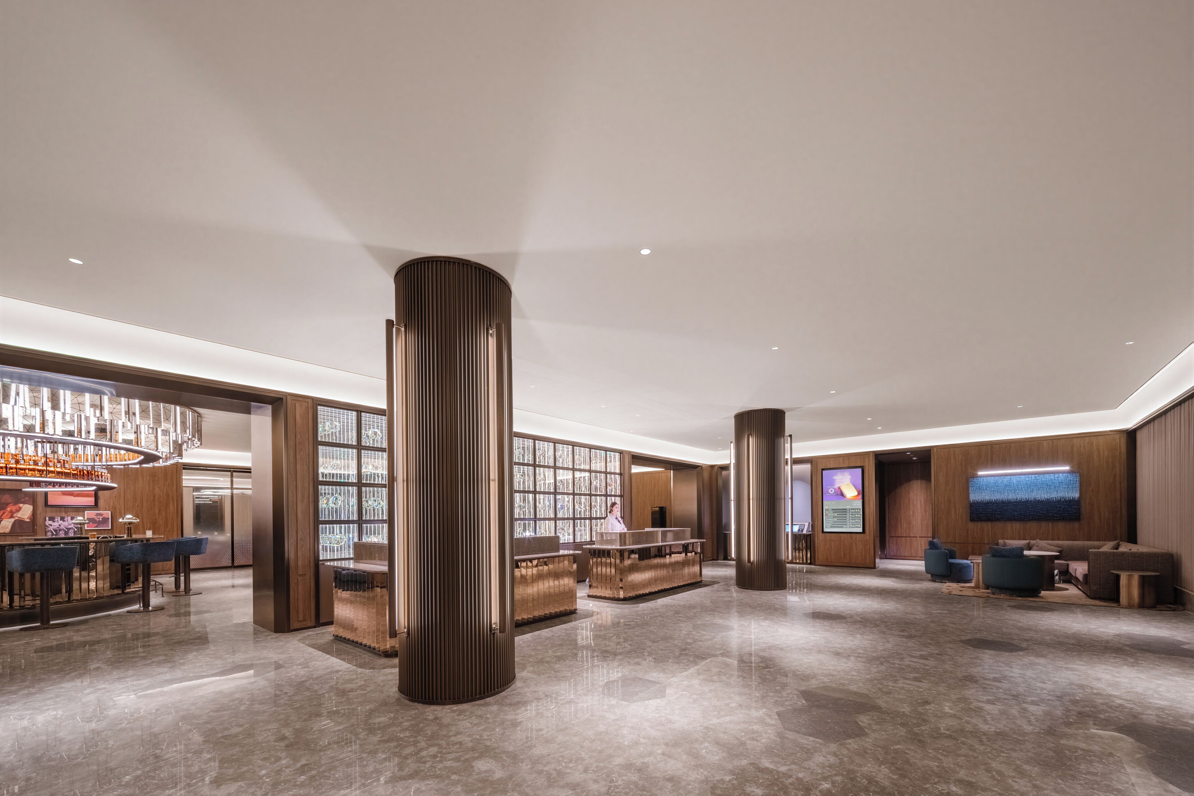 A modern lobby with a reception desk, seating area, and a bar.