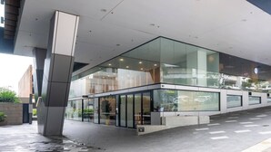 En moderne bygning med en glasfacade, et 'QUEST' skilt og et 'Clarity' logo.