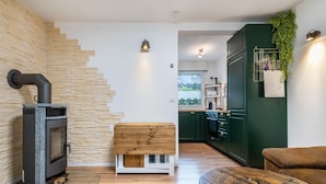 Une cuisine moderne dotée d’un poêle à bois encastré, d’un banc en bois et d’une table à manger au design inspiré d’une boussole.