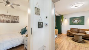 Une chambre à coucher avec un lit, un ventilateur de plafond et un luminaire fixé au mur.
