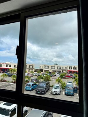 A parking lot with various vehicles, including cars and vans, and a building with signage for medical facilities in the background. - The Weekender at One West Near Beaches & Airport (Nassau)