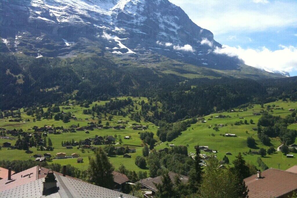 Eine gebirgige Landschaft mit einem Dorf, eingebettet in ein Tal.