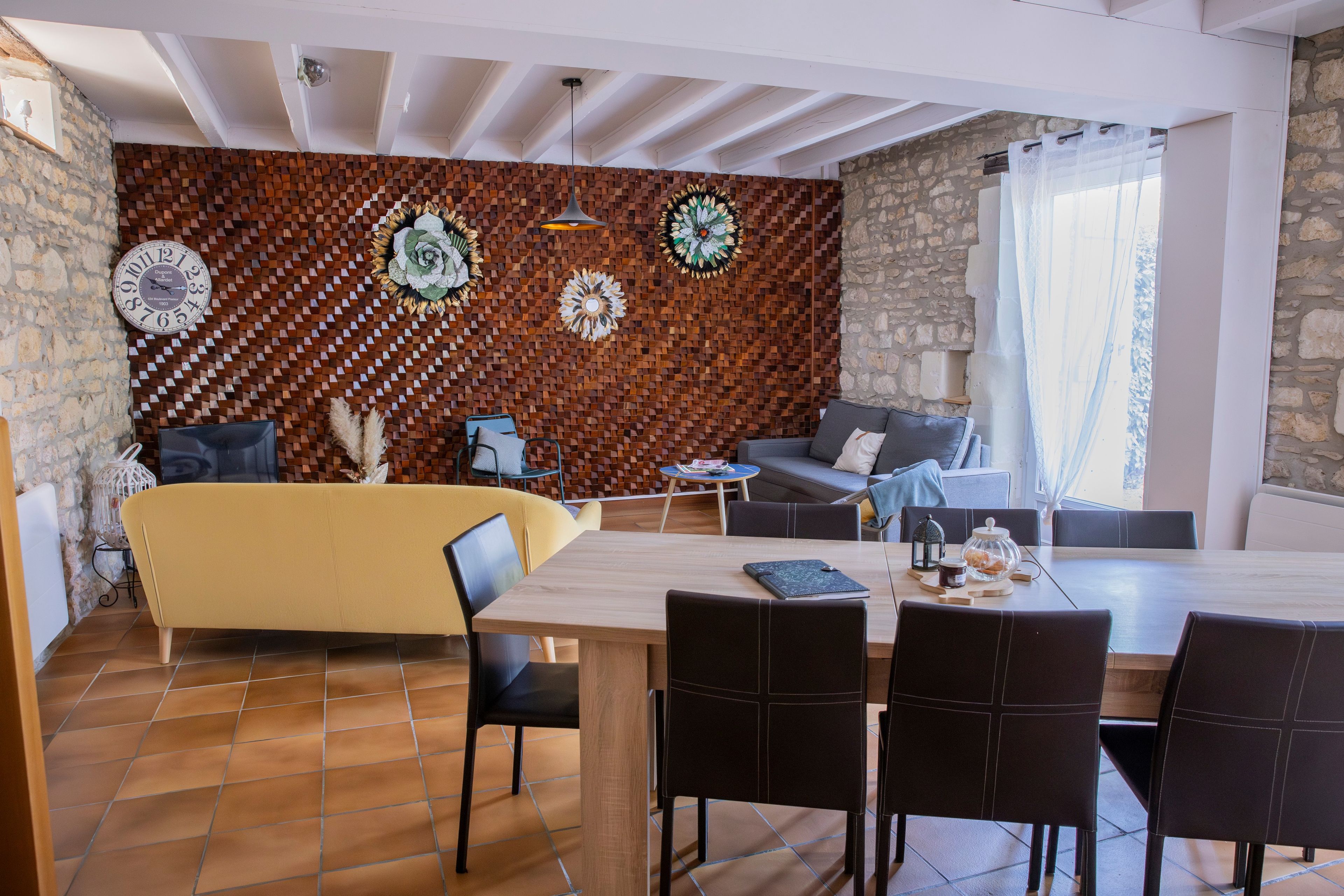 Ein moderner Essbereich mit Holztisch, schwarzen Stühlen und einer Couch.