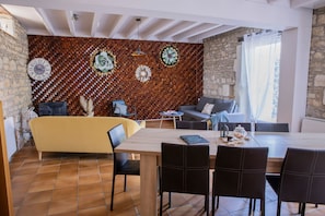 Un comedor moderno con una mesa de madera, sillas negras y un sofá.