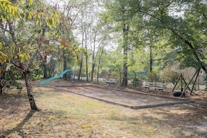 Un parque infantil con un tobogán y un banco.