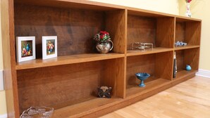 Una estantería de madera con diversos objetos decorativos.