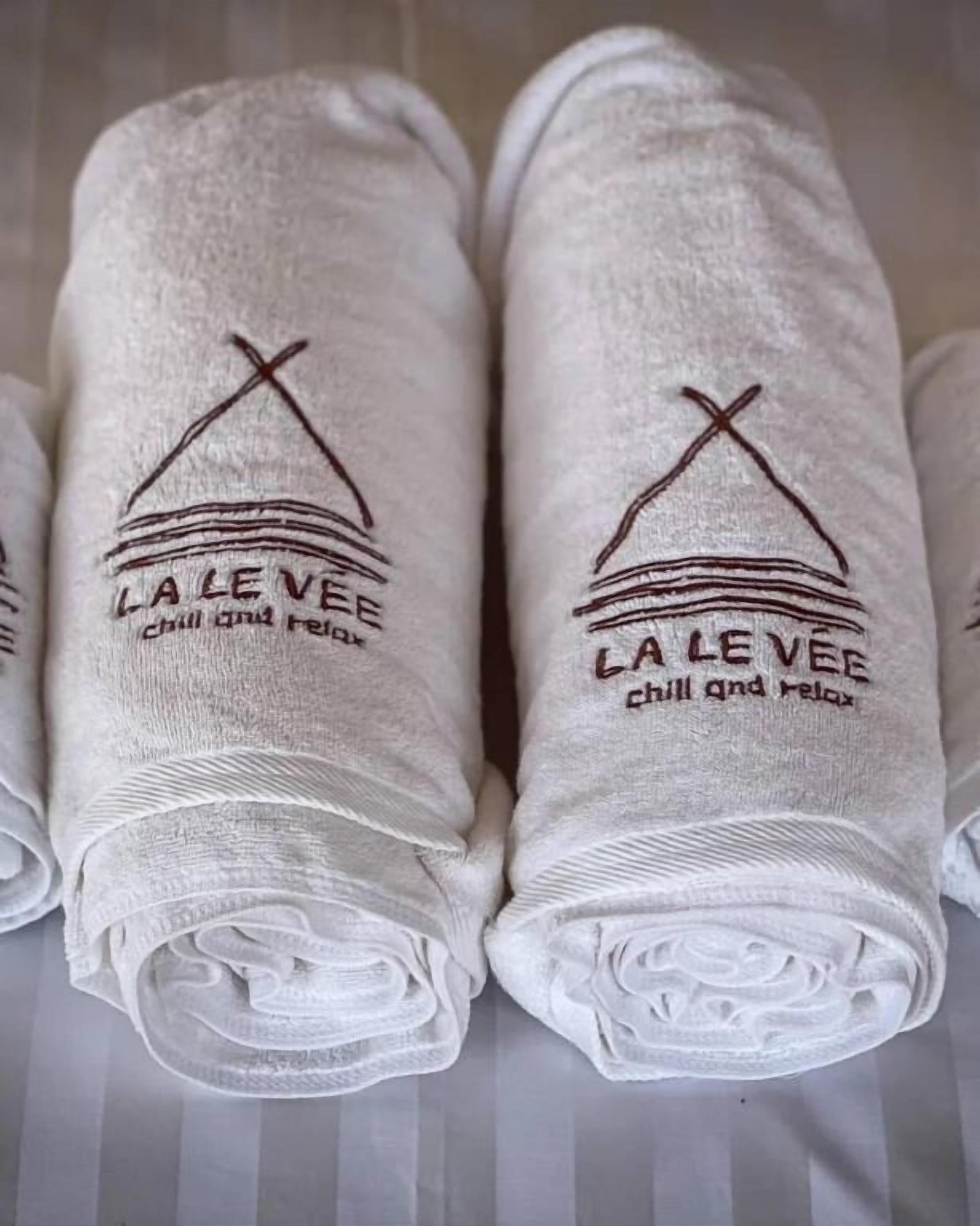 A set of neatly folded towels with embroidered text and a design.