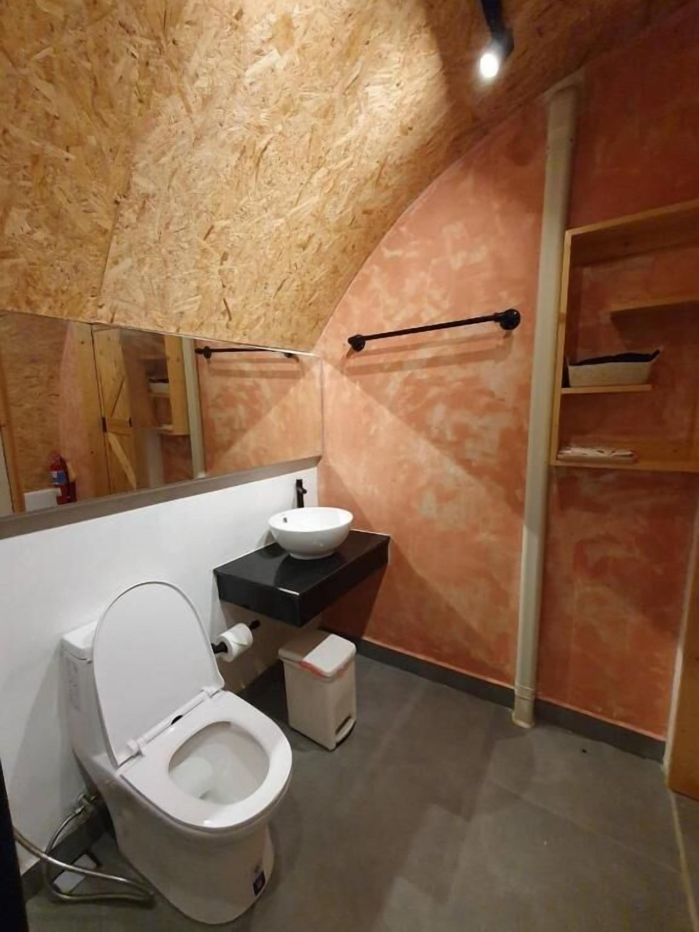 Un baño con inodoro, lavabo y espejo.