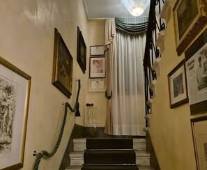 Una escalera adornada con cuadros enmarcados y un candelabro.