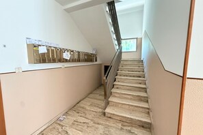 A staircase with a metal handrail, a wall-mounted locker area, and a window at the top. - A practical and welcoming 24-square-meter studio apartment, perfect for two people, located on the first floor of a building without an elevator.The property is situated just a short distance from the Modena Policlinico and is well-connected to the city  (Modena)