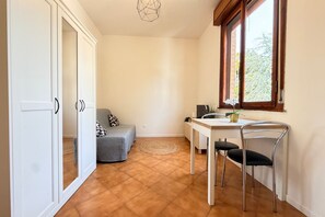 A room with a bed, a dining table with chairs, a window with a view, and a wardrobe. - A practical and welcoming 24-square-meter studio apartment, perfect for two people, located on the first floor of a building without an elevator.The property is situated just a short distance from the Modena Policlinico and is well-connected to the city  (Modena)