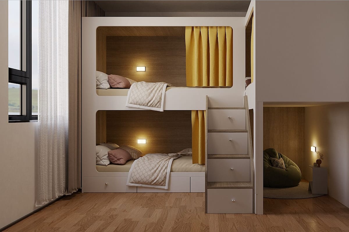 Habitación con literas, una pequeña zona de estar y una ventana con cortinas.