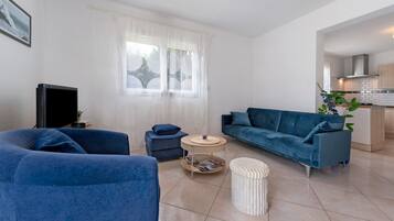 Una sala de estar con sofá, reposapiés y una mesa de centro.