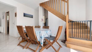 A dining area with a table, chairs, and a staircase.