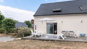 A house with a patio, outdoor furniture, and a covered area.
