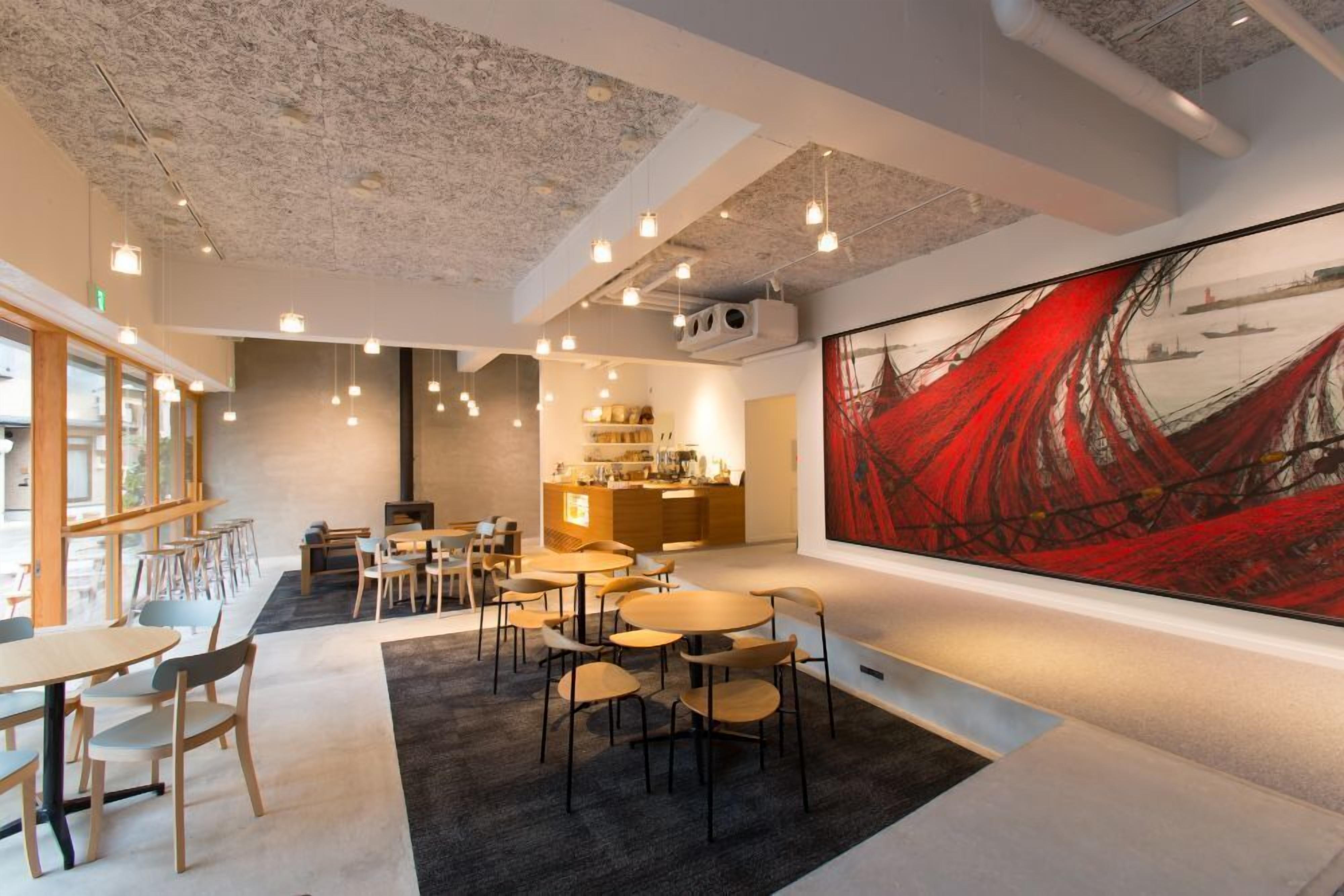 A modern interior with a dining area, kitchen, and a large abstract painting.