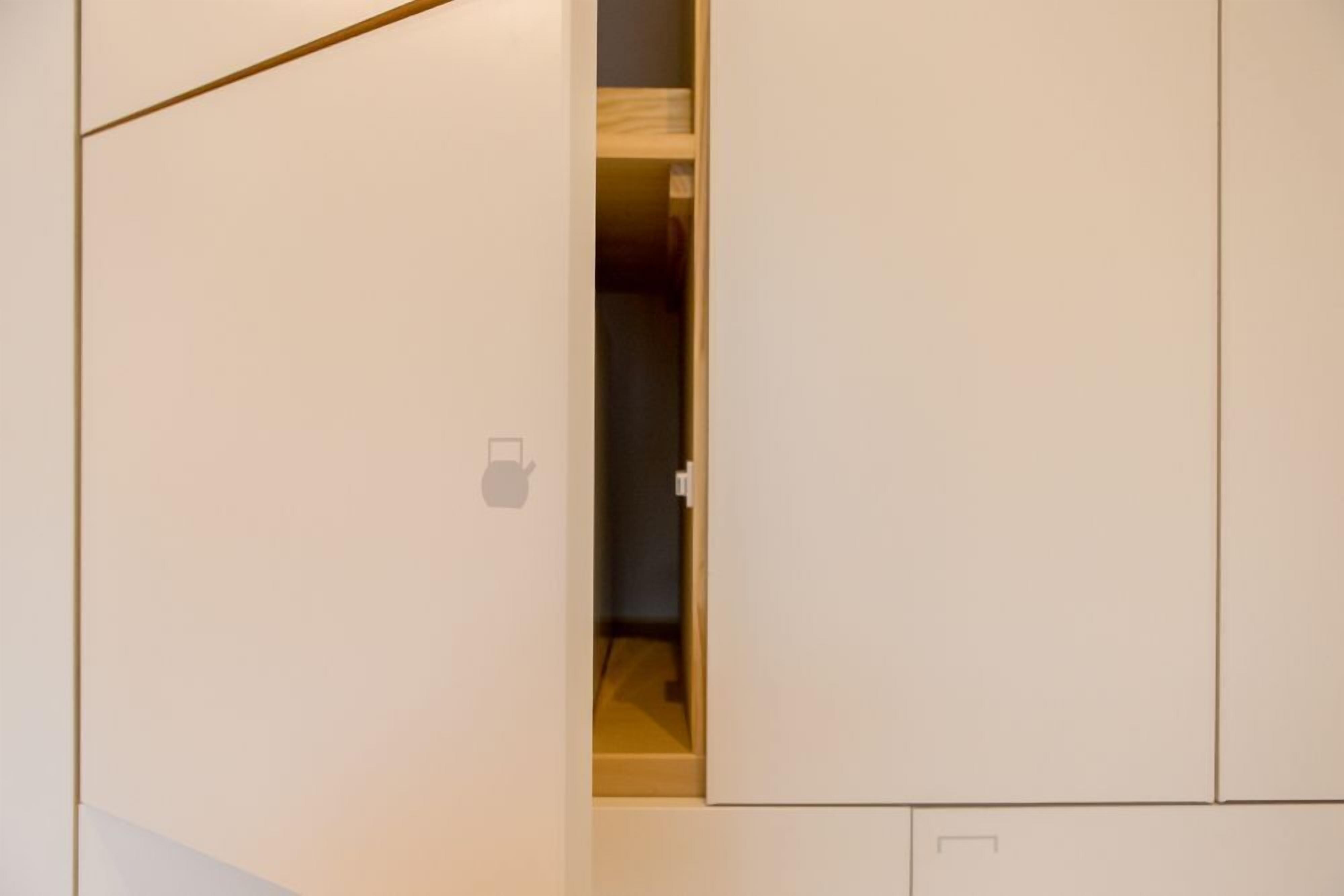 Une pièce avec une armoire, une porte et un placard.