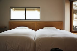 A room with two beds, a window, and a view of the outside. - TSUCHIYA Kinosaki onsen (Toyooka)
