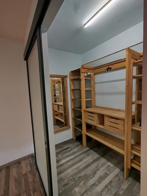 Una habitación con un armario de madera, un espejo y una lámpara en el techo.