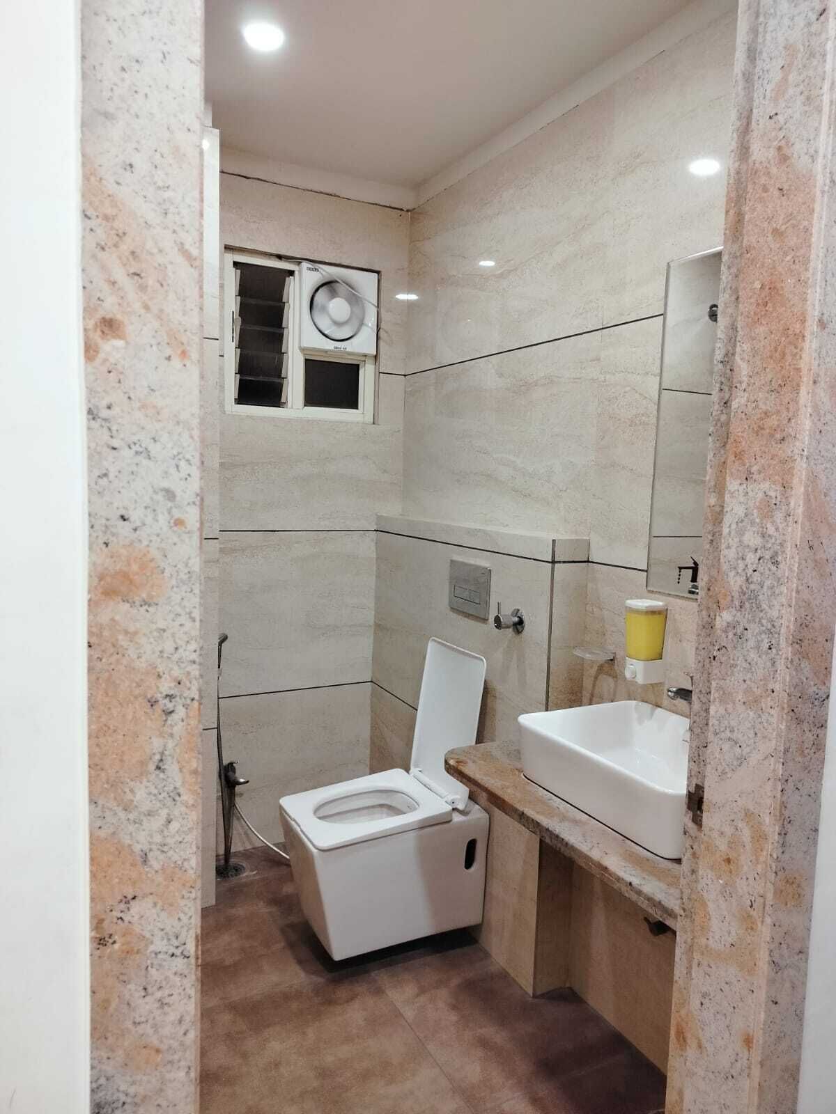 Um banheiro compacto com vaso sanitário, pia e espelho.