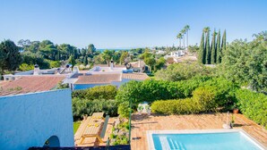 Zona residencial con piscina, un patio con mesa y sillas, y vista al mar.