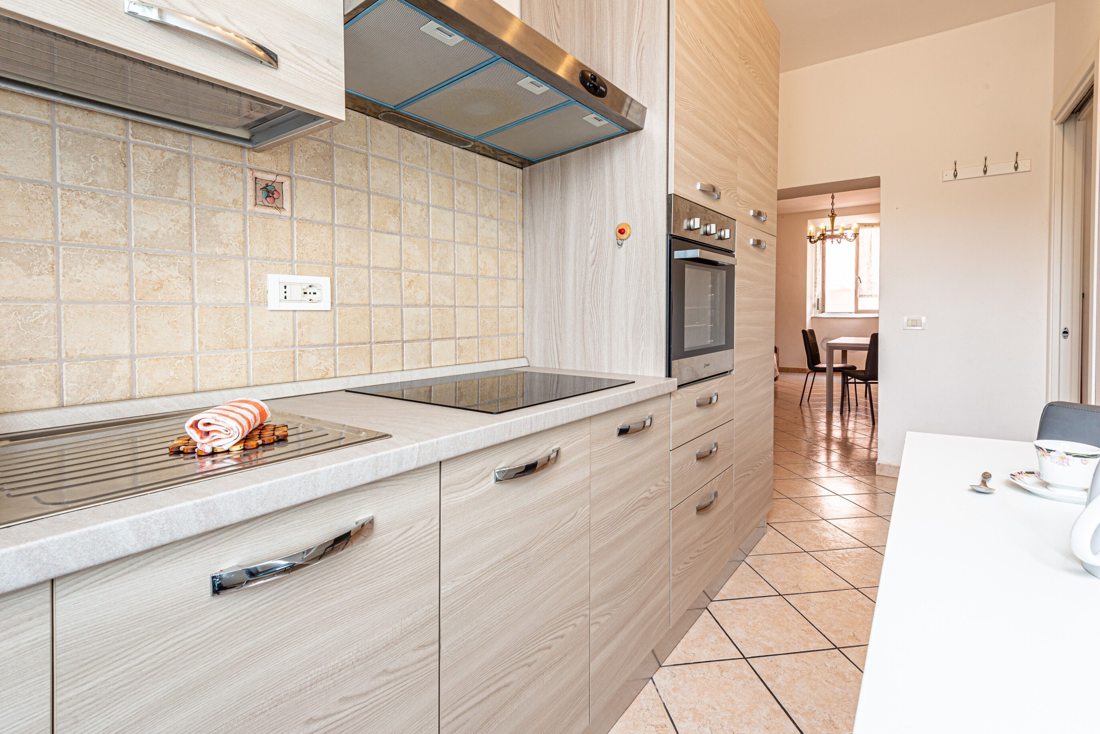 Een moderne keuken met een inbouwoven, een kookplaat en een groot eiland met een spoelbak.
