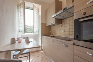 Una cocina moderna con ventana, una mesa con sillas y un horno empotrado.
