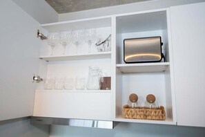 A kitchen with white cabinets, a toaster, and glassware. - Corporate Stays First del Sol (Asunción)