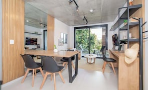 A modern interior with a dining area, a kitchen, and a balcony with a view. - Corporate Stays First del Sol (Asunción)