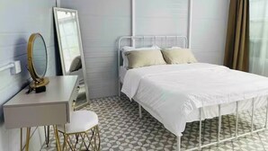Ein Schlafzimmer mit einem Bett, einem Nachttisch, einem Spiegel und einem Fenster mit Vorhängen.