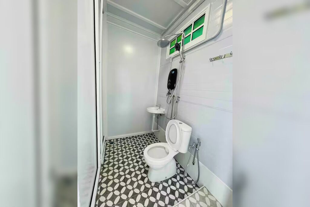 A small, compact bathroom with a toilet, sink, and shower.