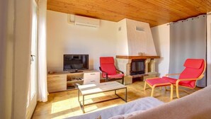 A living room with a fireplace, wooden ceiling, and a television. - The Van Gogh House: 3 bedrooms, 4 beds, and easy parking (Tournefeuille)