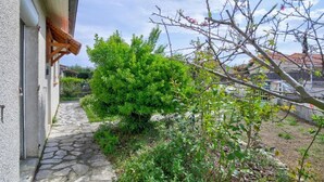 A stone pathway leading to a building with a wooden awning, surrounded by lush greenery and a clear sky. - The Van Gogh House: 3 bedrooms, 4 beds, and easy parking (Tournefeuille)