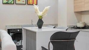 A modern kitchen with a central island, a built-in dishwasher, and a stove. - Chennad Apartment  (Abuja)