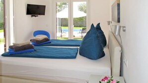 Een kamer met twee bedden, een televisie en uitzicht op de omgeving.