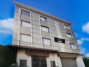A multi-story building with a sign indicating 'Collection' and 'Company Services.' - Suite Hotel TR (Amritsar)