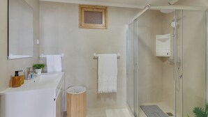 A bathroom with a shower, sink, and mirror. - Maiata Beach House 2 (Madeira)
